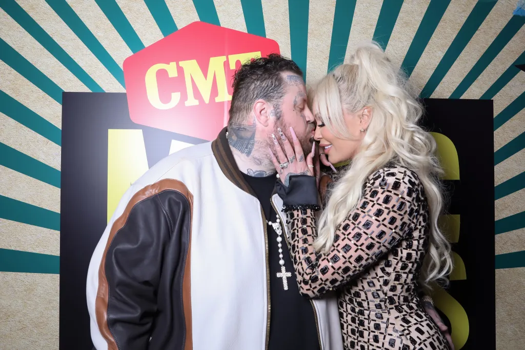 Jelly Roll and Bunnie XO share a kiss at the 2024 CMT Music Awards.