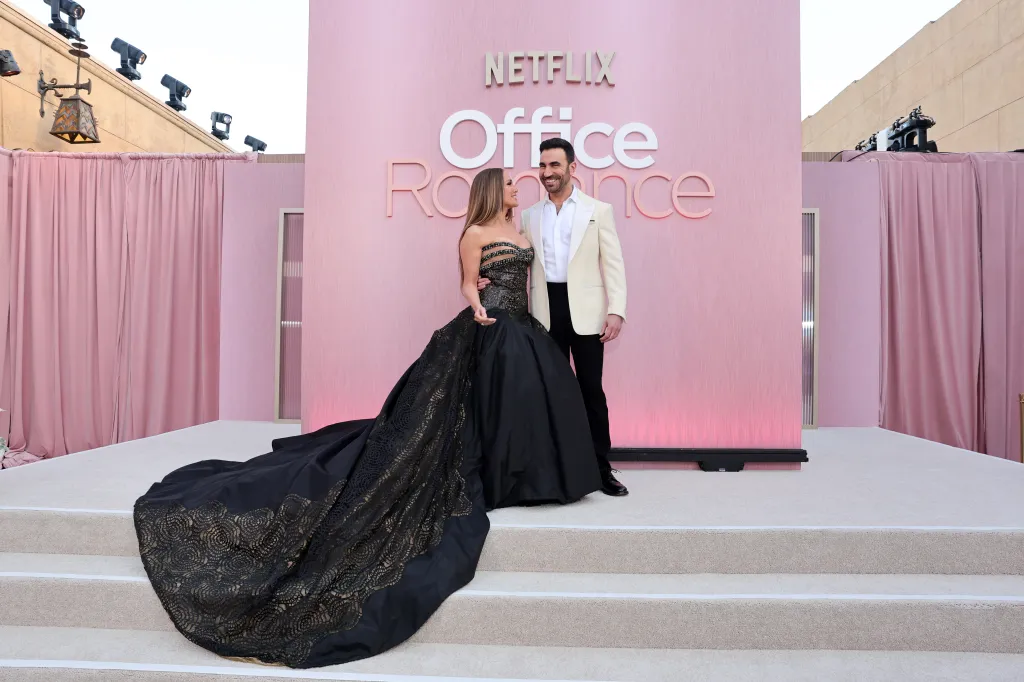 Jennifer Lopez in a black gown and Brett Goldstein in a cream suit at the 