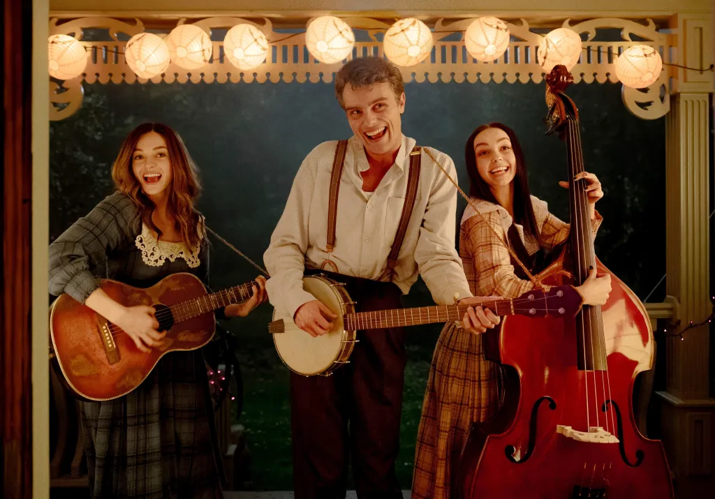 Olivia Rose Keegan, Cameron Scott Roberts, and Savannah Lee Nassif smiling and playing musical instruments in 