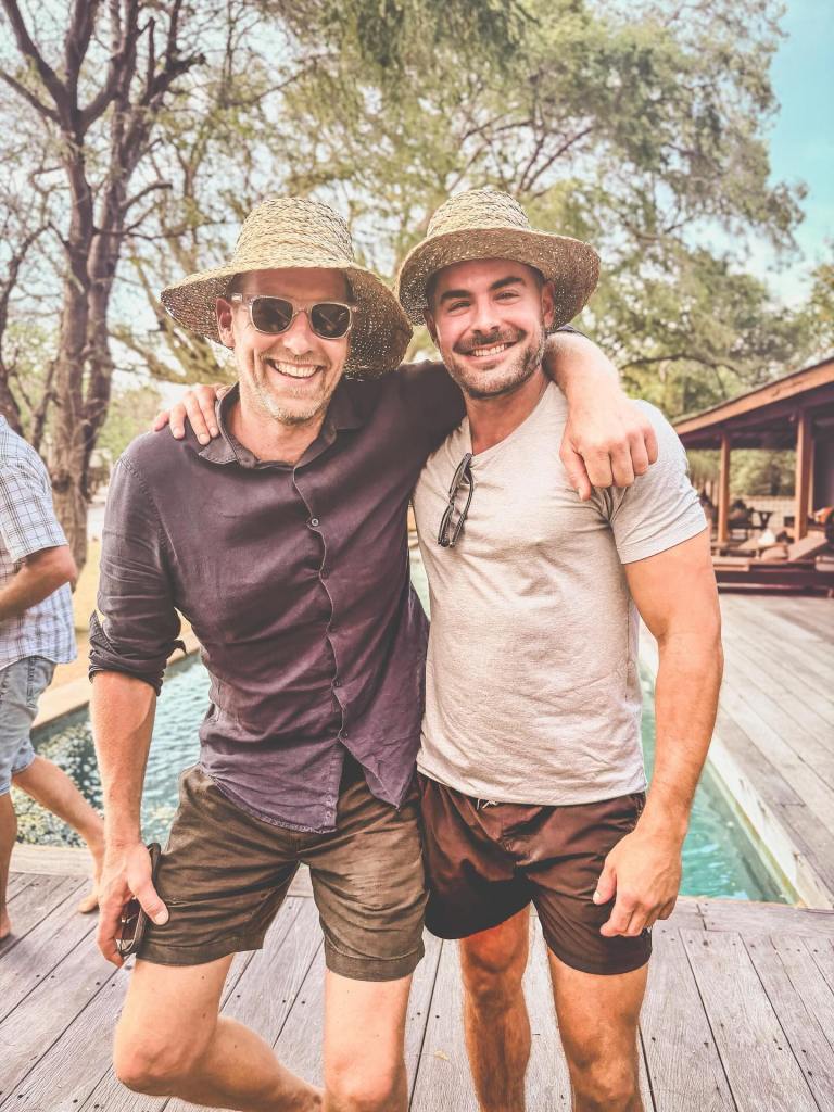 Zac Efron and Joost Bakker smiling with their arms around each other.
