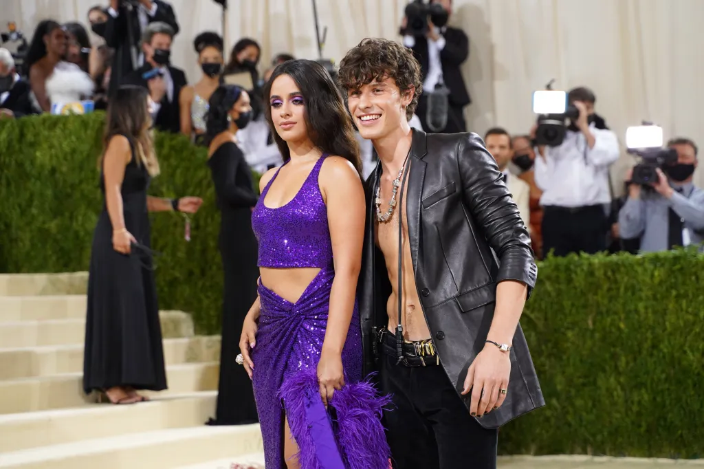 Camila Cabello in a sequined purple outfit and Shawn Mendes in an open black leather jacket at the Met Gala.
