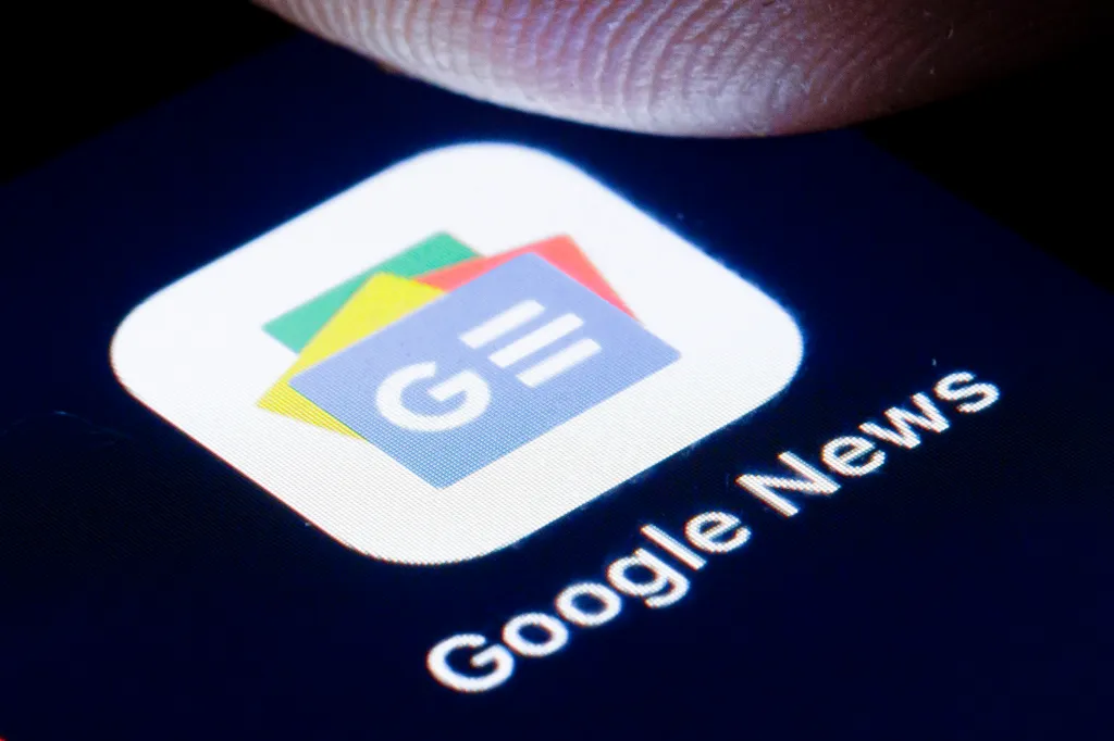 Close-up of a smartphone screen showing the Google News logo and text with a finger touching the screen.