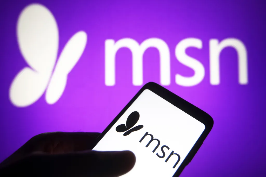 Photo illustration of the MSN logo displayed on a smartphone screen and in the background.