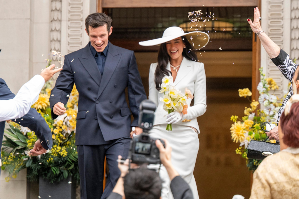 Dua Lipa and Callum Turner leaving their wedding with confetti thrown in the air.