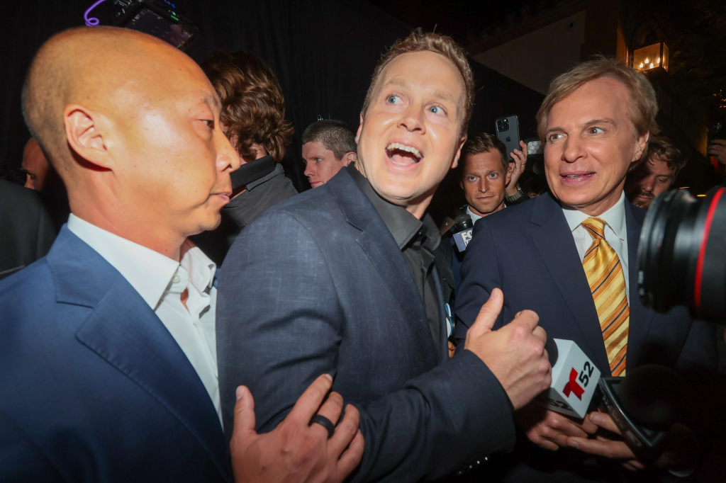 Spencer Pratt, flanked by other men, smiles widely at his election night watch party.