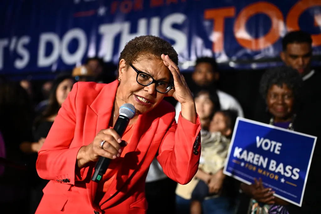 Los Angeles Mayor Karen Bass speaking into a microphone with her hand to her forehead.