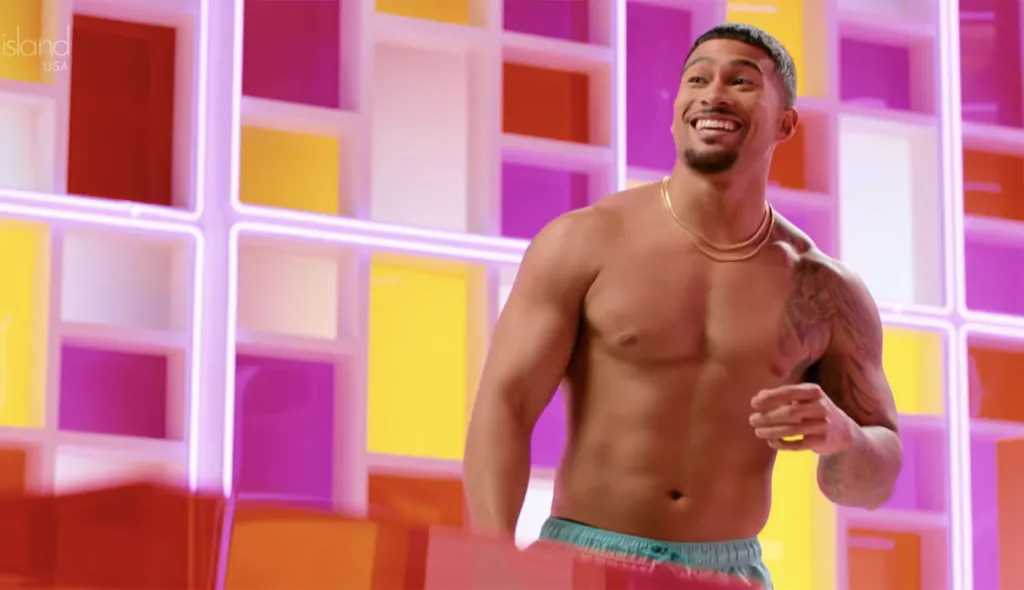 Sean Reifel smiling with a colorful background on Love Island.