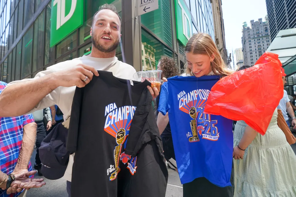 Lucas and Kate, tourists from Australia, holding up NBA Champions T-shirts for the New York Knicks.