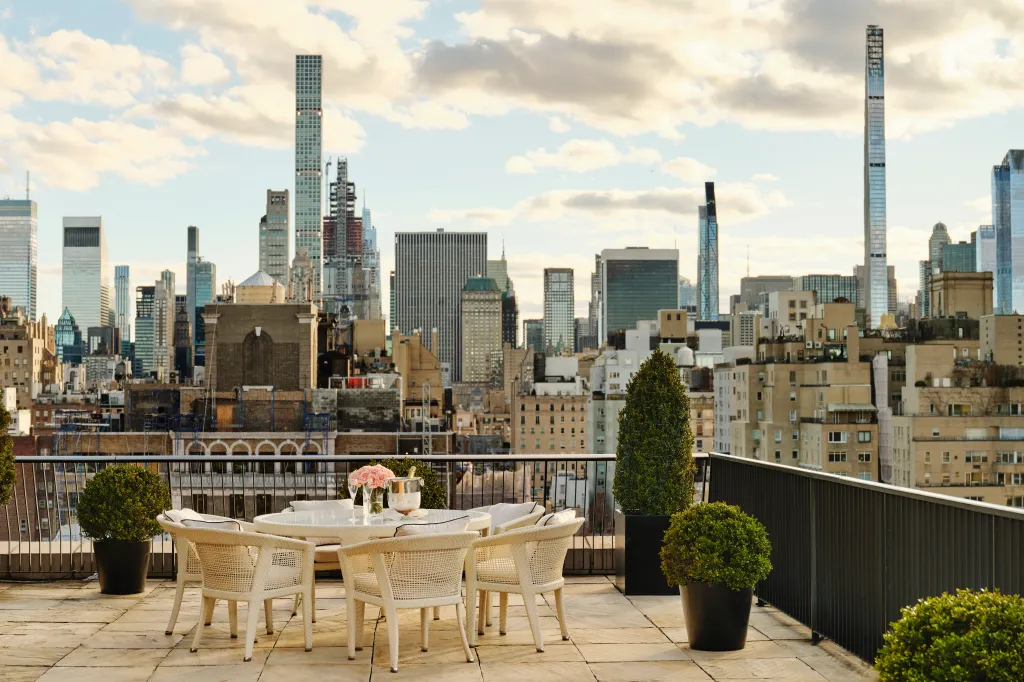 Rooftop terrace with a set table and panoramic city views of New York City.