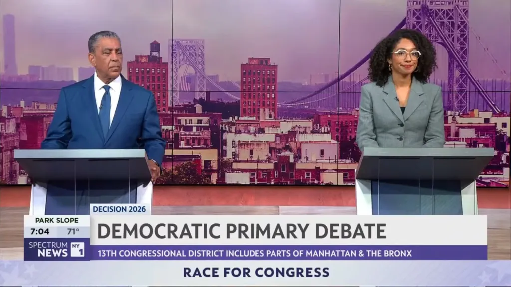 Two political candidates debate at podiums in front of a New York City skyline.