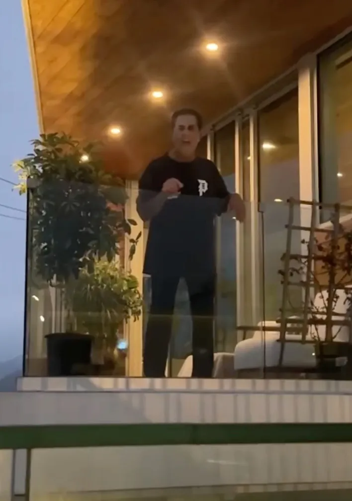 Man yelling racial slurs from a balcony.