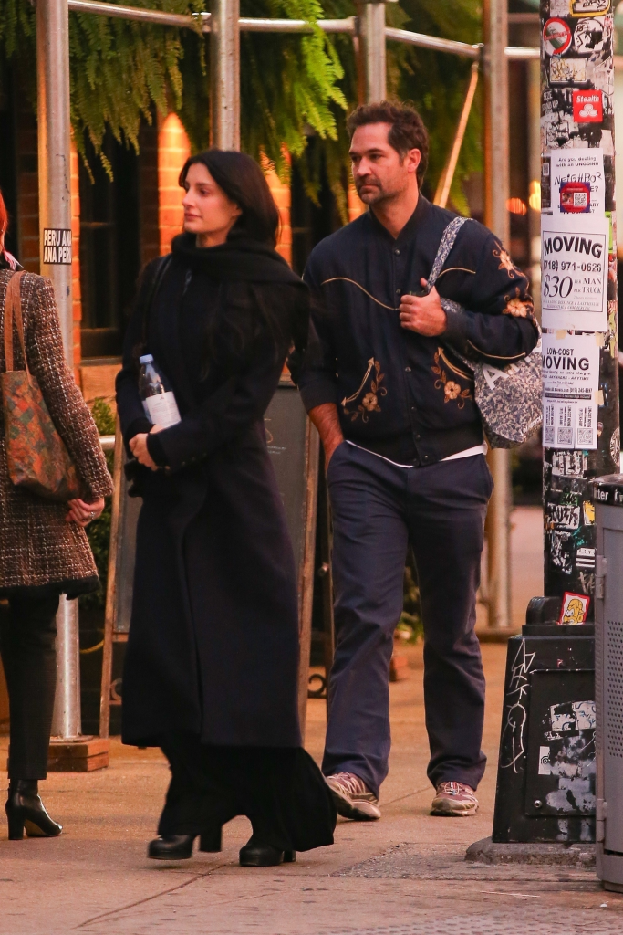 Manuel Garcia-Rulfo wearing an embroidered jacket and Audrey McGraw in a long black coat, walking in New York City.