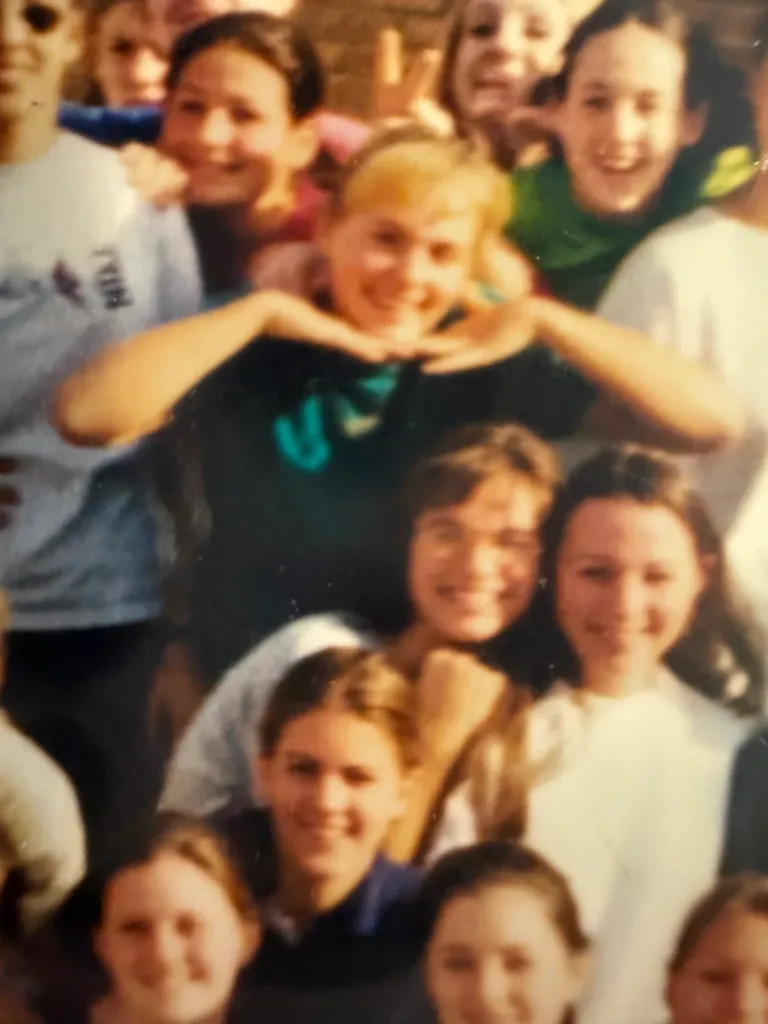 Helphenstein is seen smiling with her hands under her chin at Mountain Park. Richter is in the green behind her.