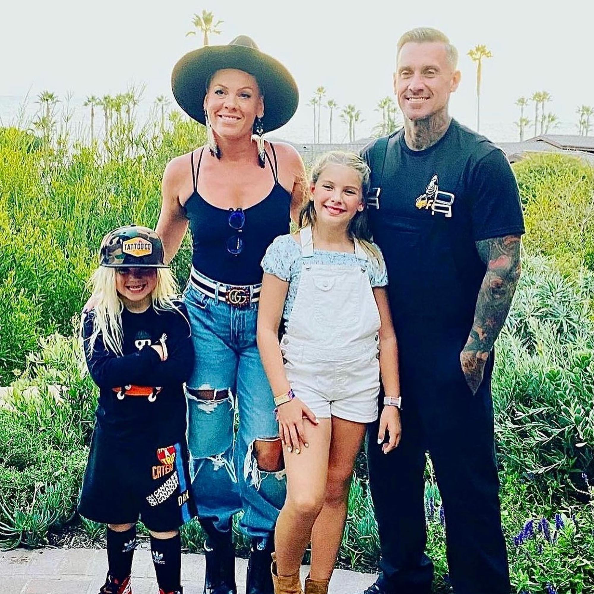 Pink, her husband Corey Hart, and their two children, Willow and Jameson, posing outdoors.
