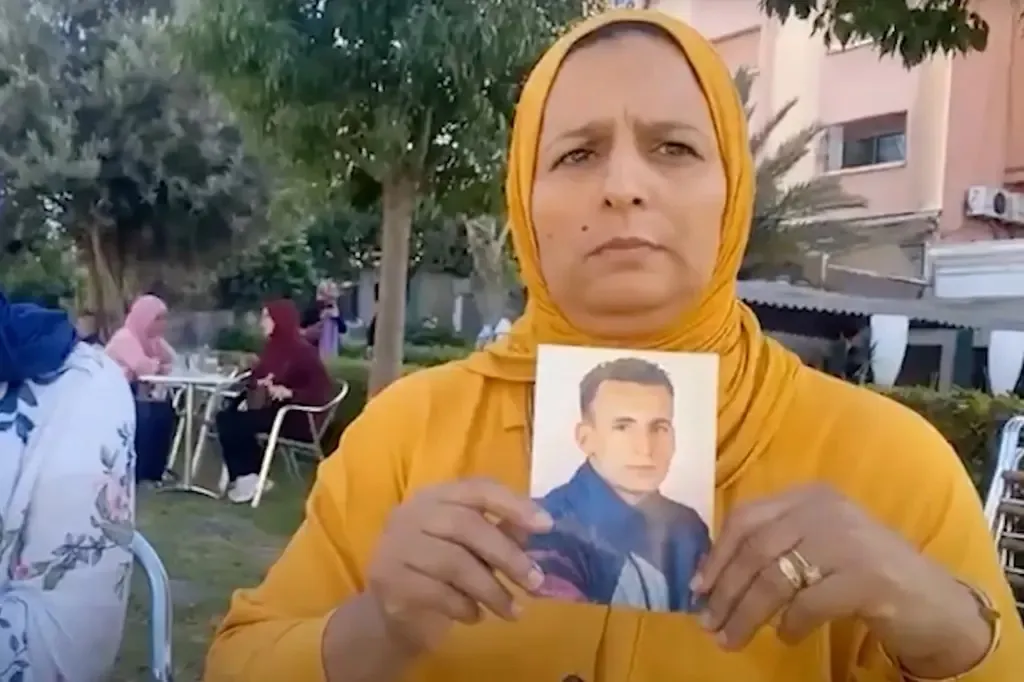 A relative of Mezgoui holds up a photo of the Moroccan national.