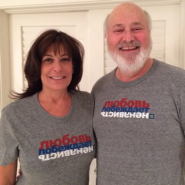 Michele and Rob Reiner smiling and wearing matching gray t-shirts with Russian text 