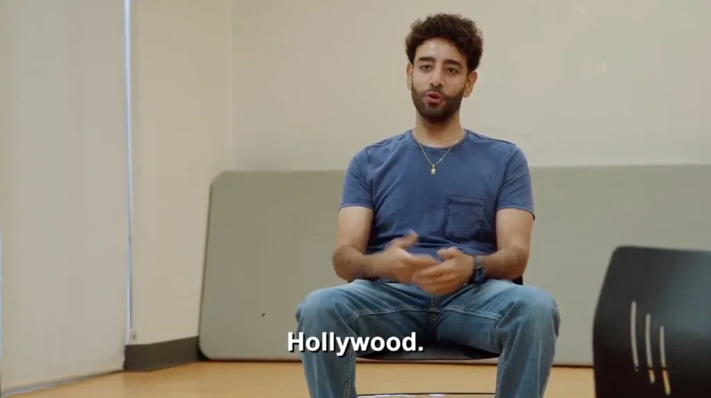 Mido from 90 Day Fiance wearing a blue t-shirt and jeans.