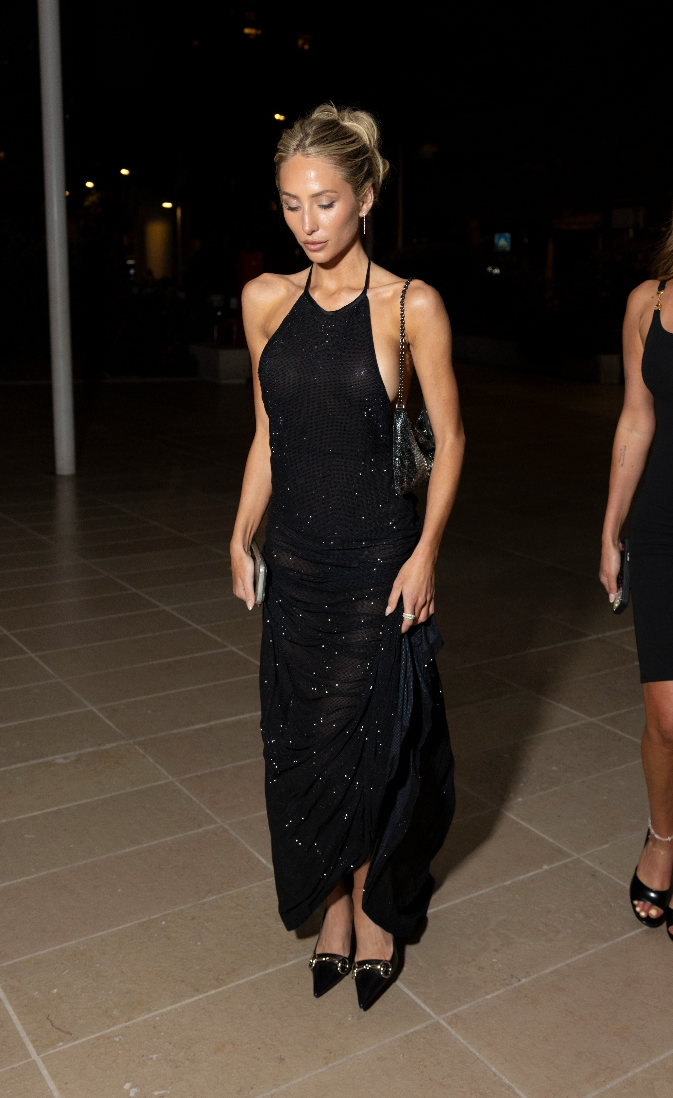 Stassie Karanikolaou arriving at the Gucci Monaco party in a black embellished halter dress.