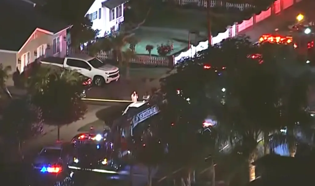 Overhead view of a crime scene with police and emergency vehicles at night.