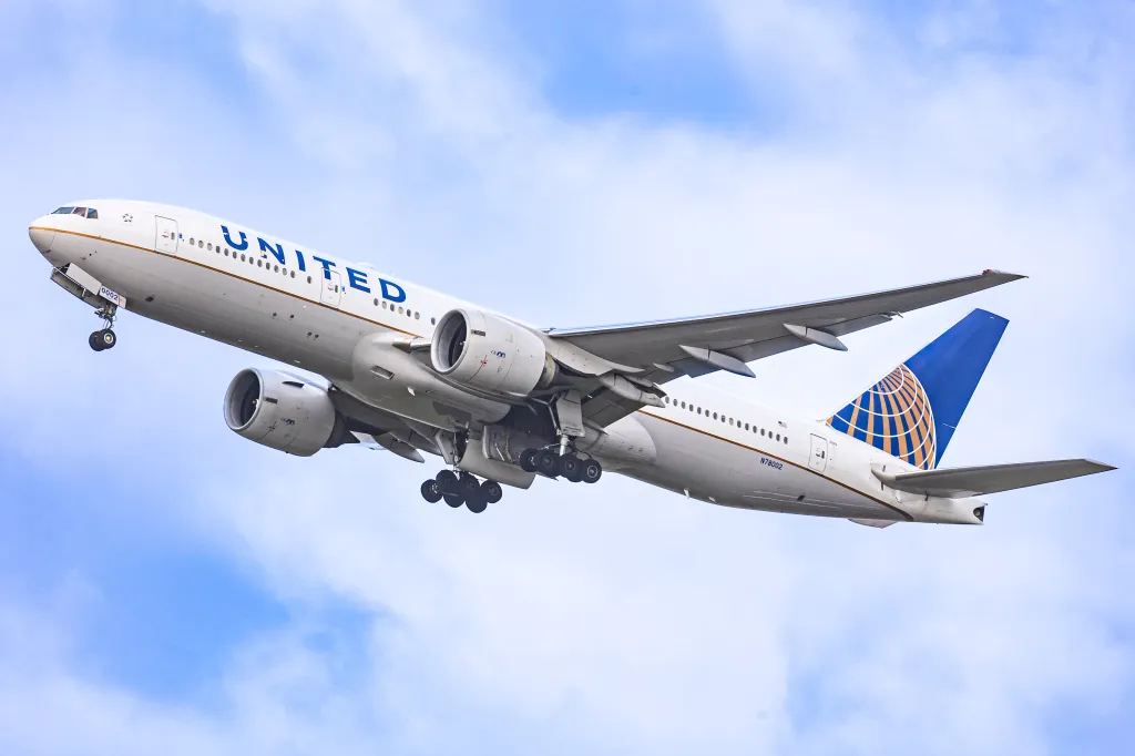 A United Airlines Boeing 777-200 aircraft departing from Amsterdam.