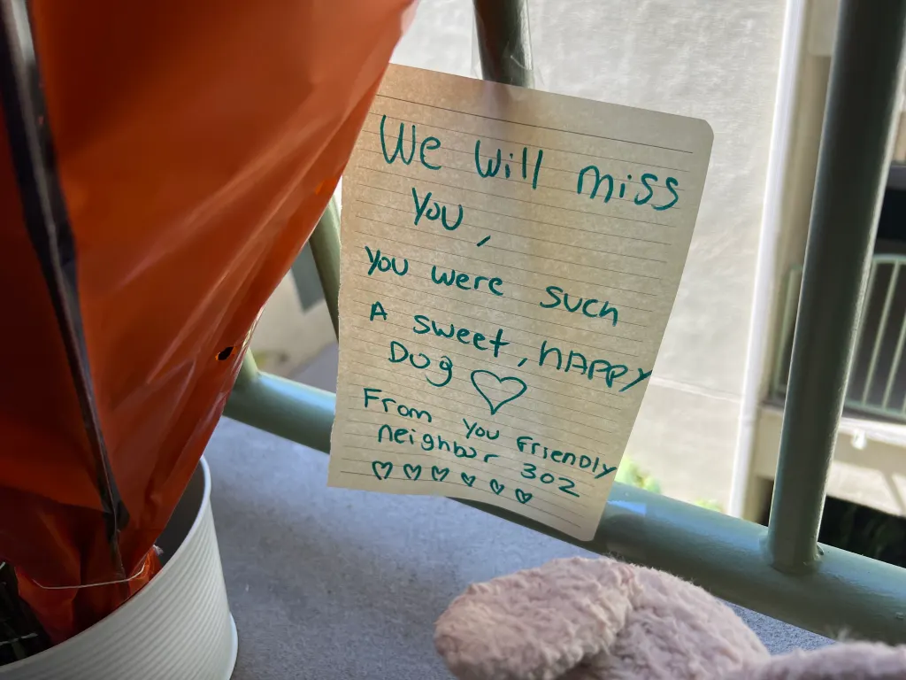 A handwritten note on lined paper attached to a railing reads,