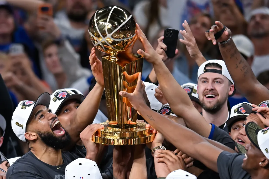 The New York Knicks basketball team celebrates with the Larry O'Brien Championship Trophy.