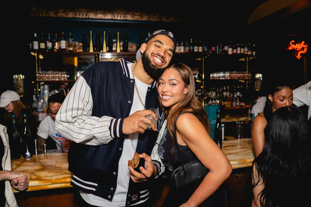 Karl-Anthony Towns and Jordyn Woods posing at Flyfish Club after the Knicks championship celebration.