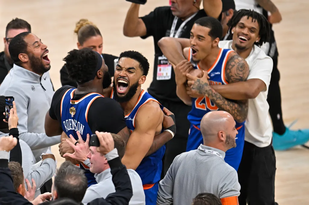 Karl-Anthony Towns and Og Anunoby embrace while celebrating a victory.