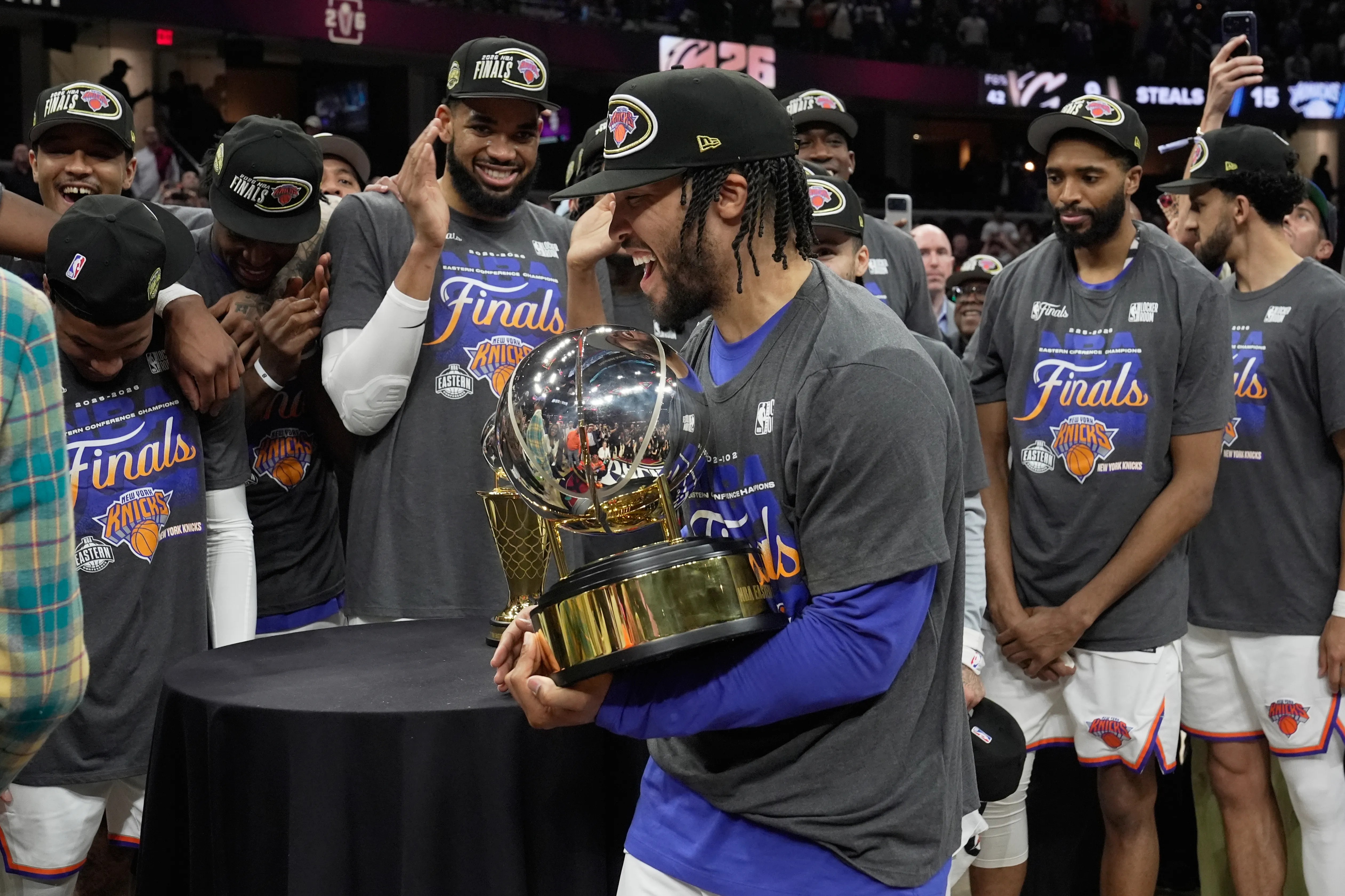 Jalen Brunson holds the Eastern Conference Championship trophy surrounded by his New York Knicks teammates wearing 