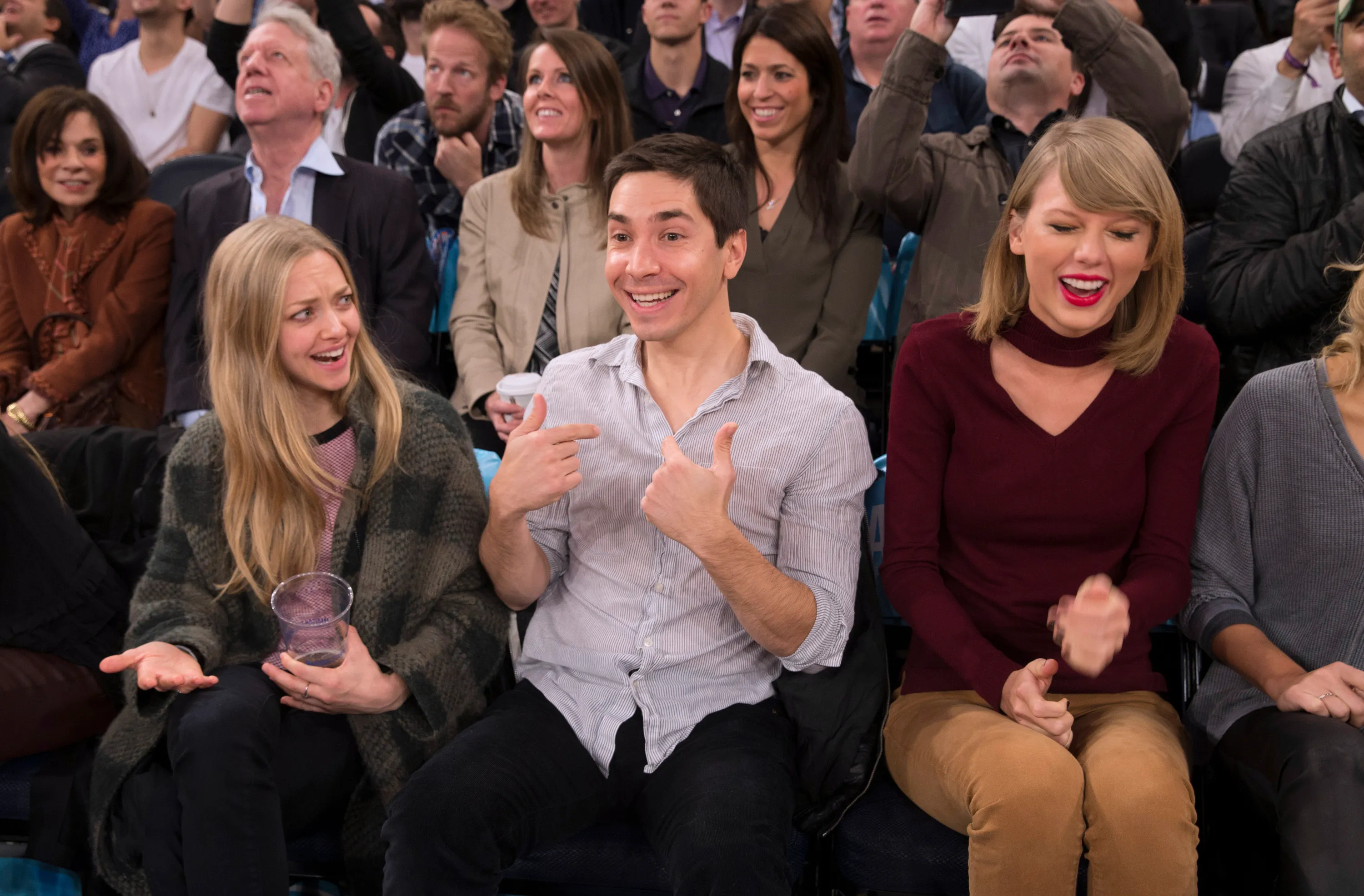 Actors Amanda Seyfried and Justin Long with singer Taylor Swift at a 2014 game.
