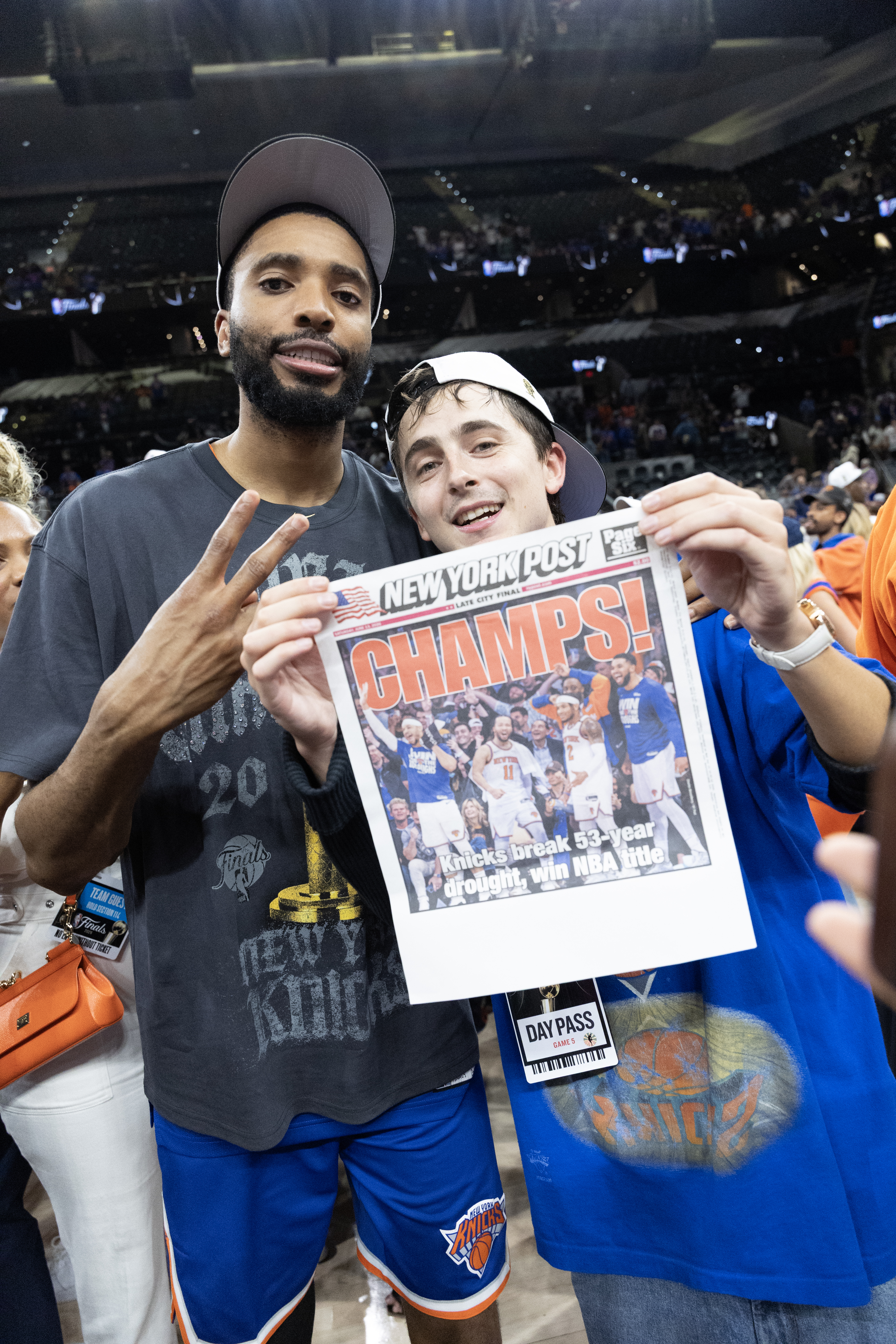 Mikal Bridges and Timothée Chalamet hold up The New York Post newspaper with the headline 