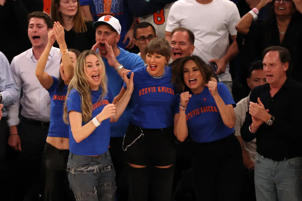 Este Haim, Taylor Swift, and Mariska Hargitay reacting during an NBA game.