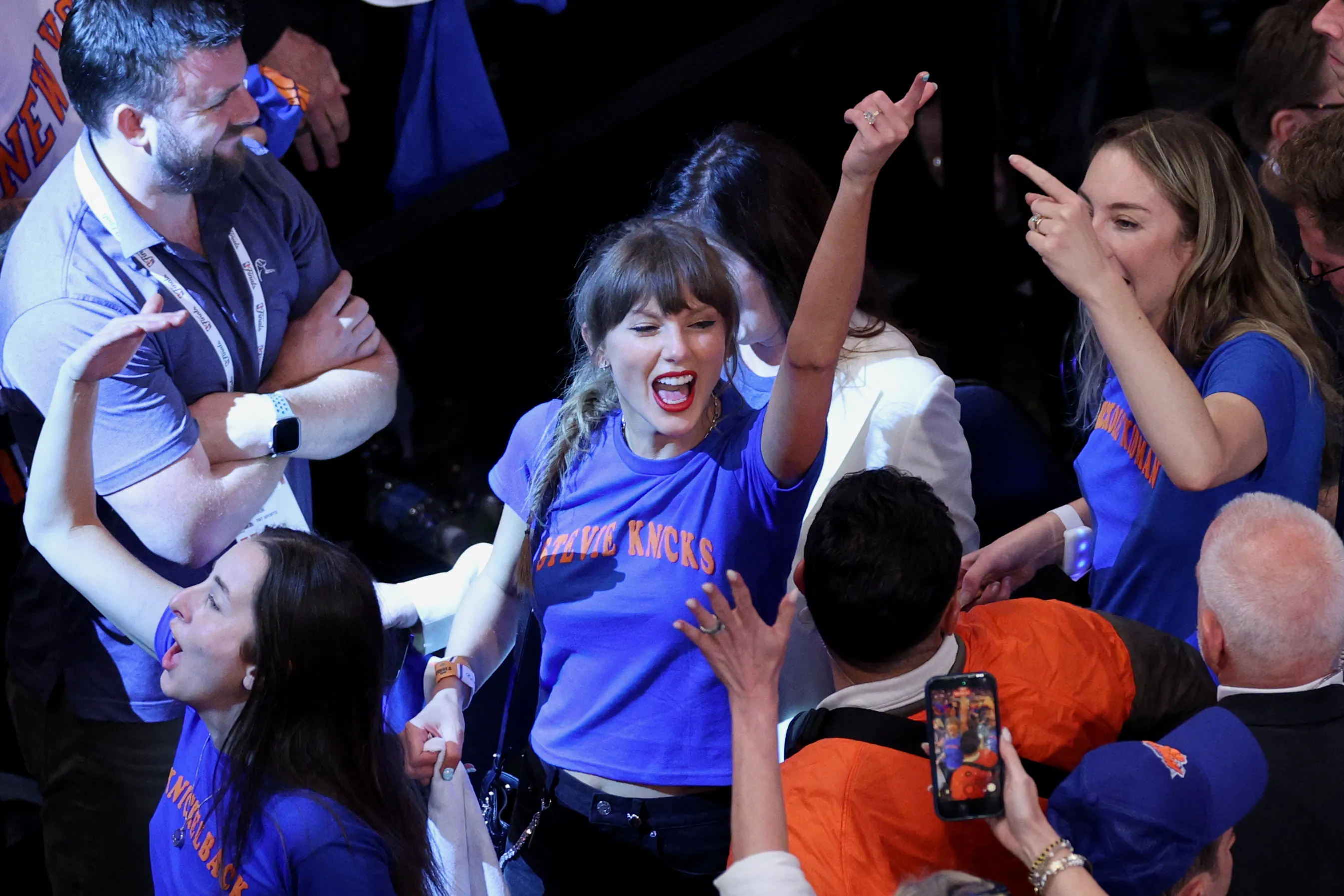 Taylor Swift celebrates with Alana Haim and Este Haim at an NBA game.
