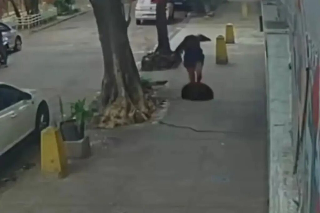 Terrifying moment woman falls down a manhole after cover gives way beneath her