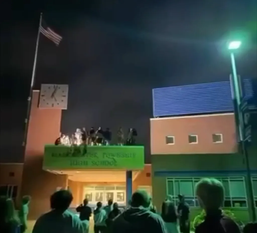 Students stand on top of the entrance to Manchester Township High School during a 
