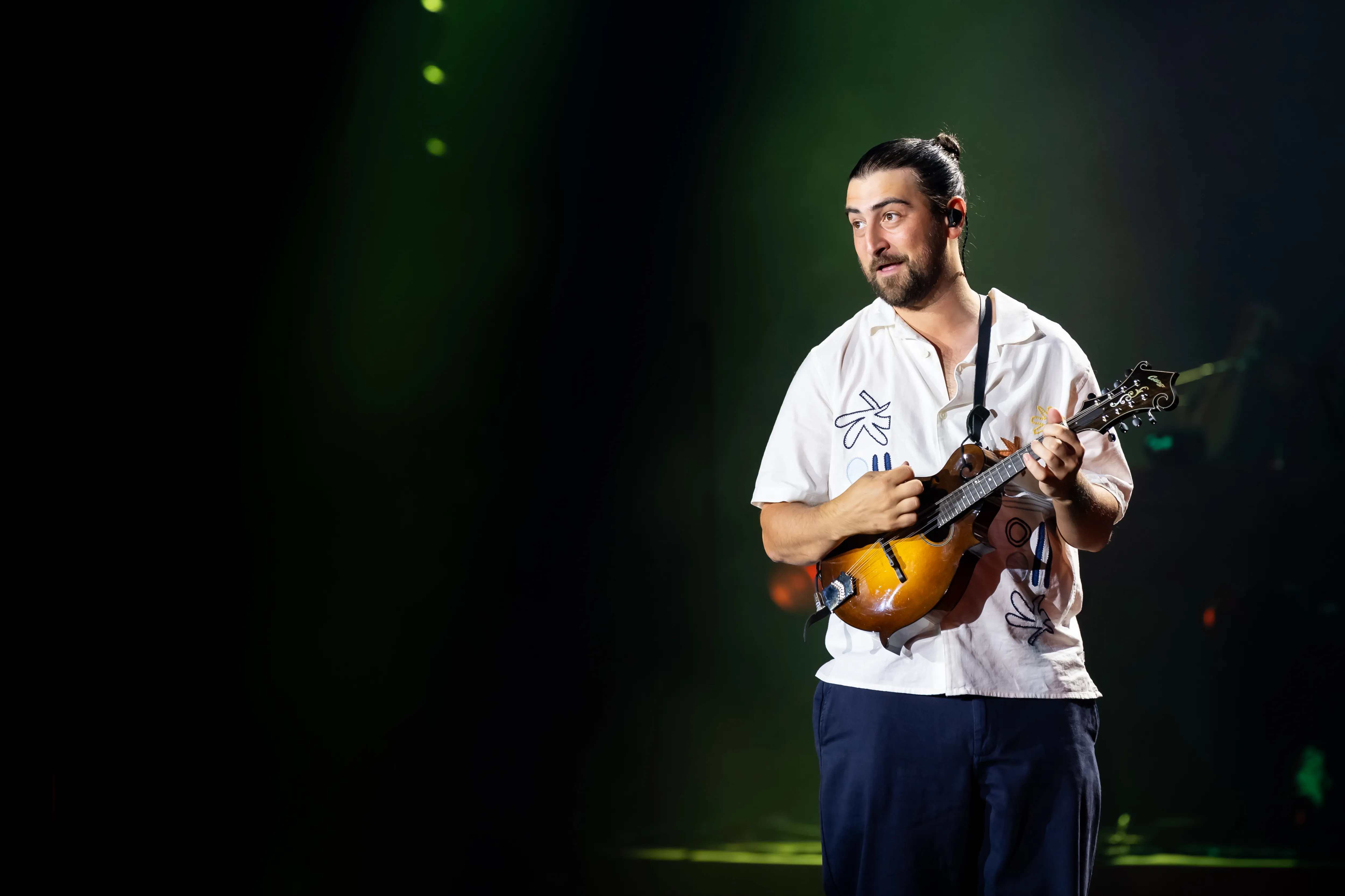 Noah Kahan playing a mandolin onstage at the Montreux Jazz Festival.