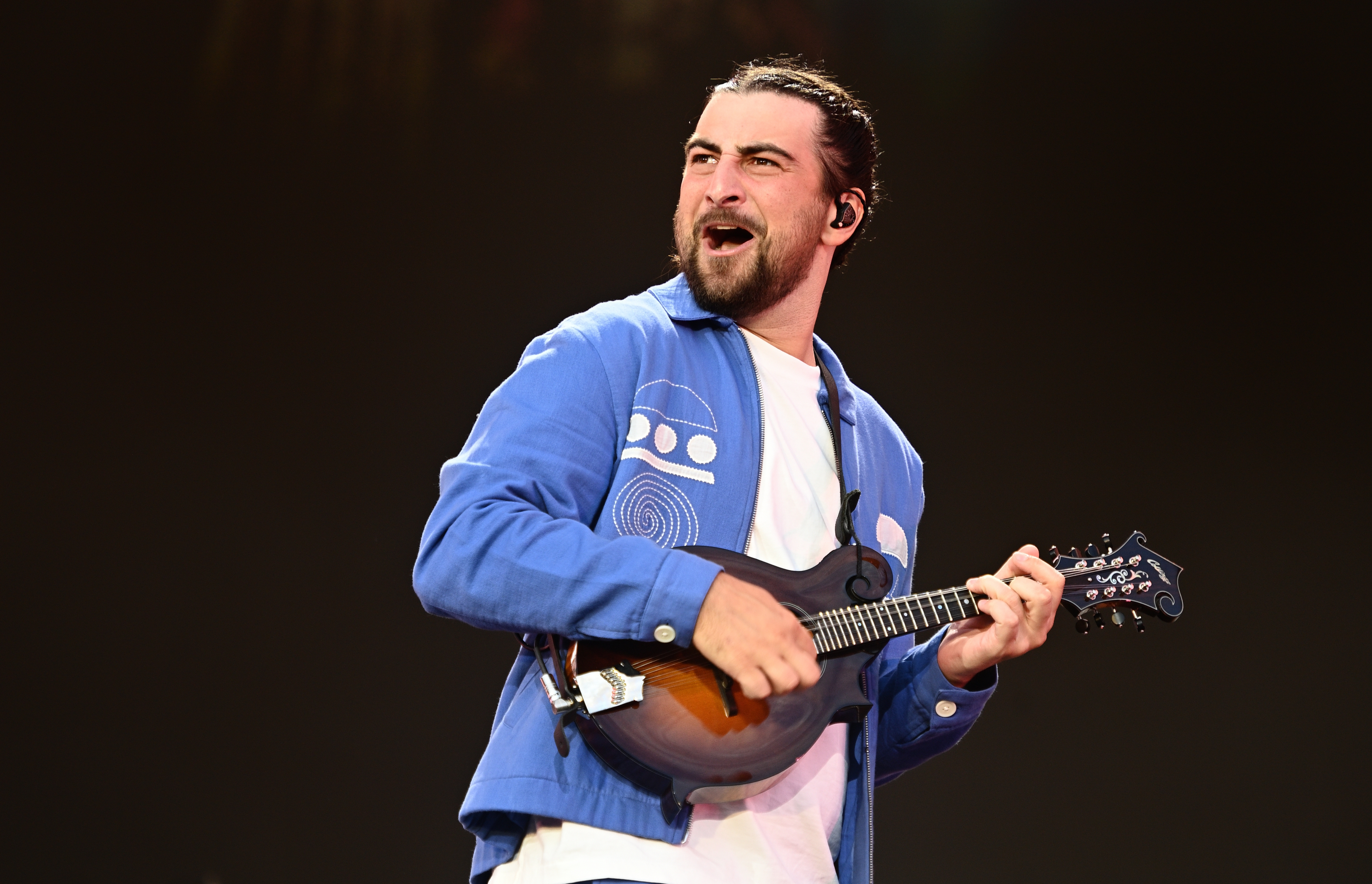 Noah Kahan performs with a mandolin.