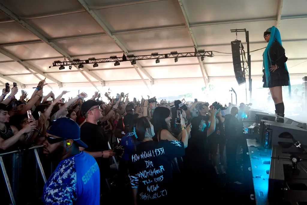 North West performs at Summer Smash, wearing a black outfit and long blue pigtails, with a crowd of people in front of her holding up phones to record.