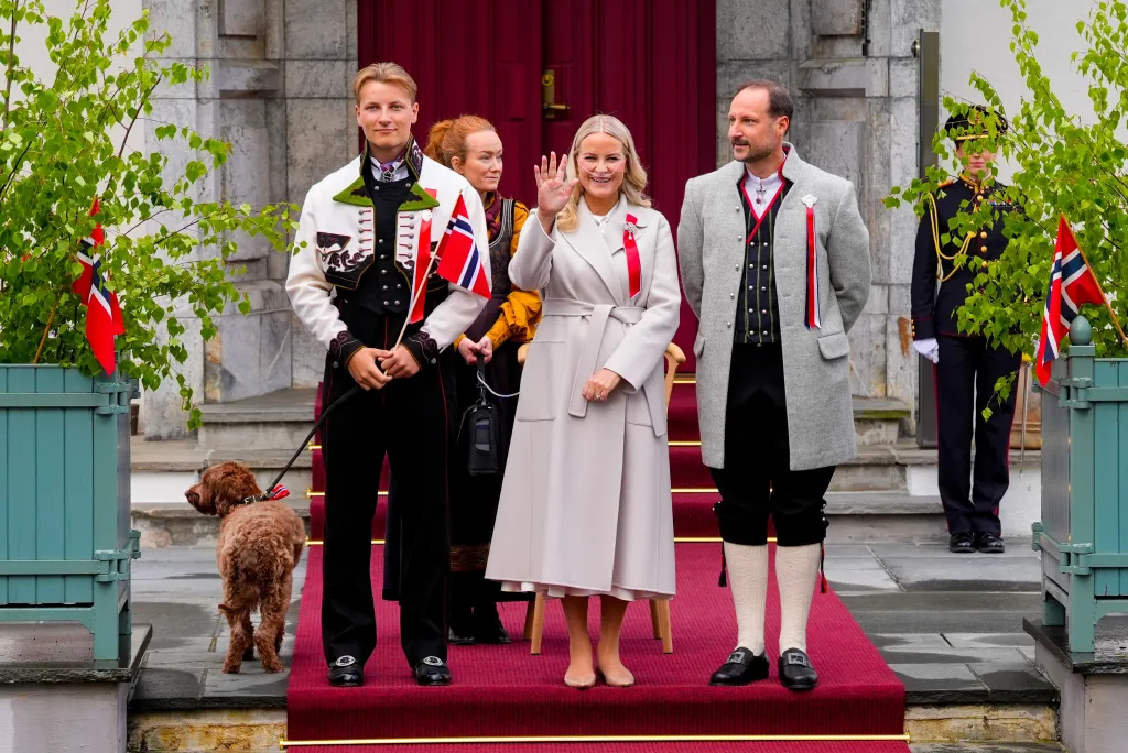 Crown Princess Mette-Marit, Crown Prince Haakon, and Prince Sverre Magnus of Norway greet a procession.