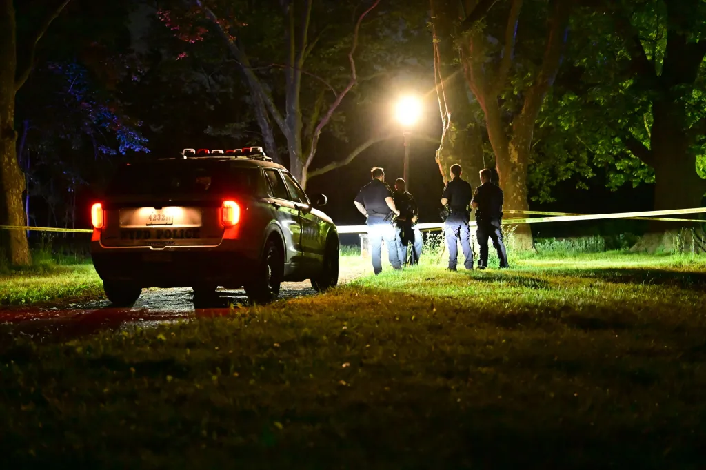 NYPD officers work at a crime scene in Kissena Lake, Queens, New York.
