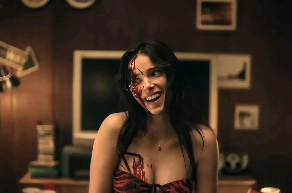 Inde Navarrette with blood spattered on her face and chest, smiling broadly.