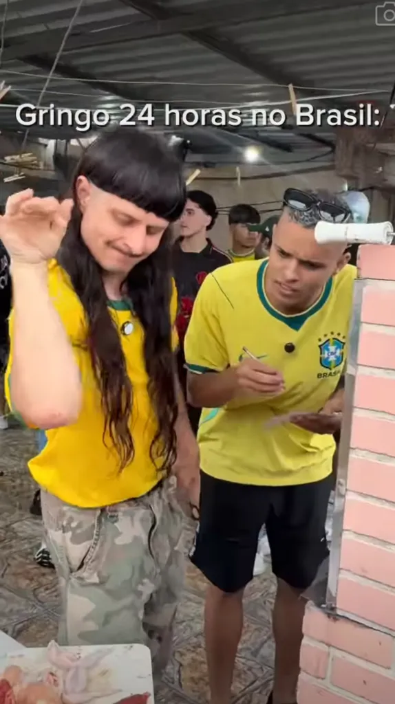 Two men wearing yellow Brazil soccer jerseys, one with a mullet haircut, are in an outdoor setting with raw chicken on a table, with text that translates to 