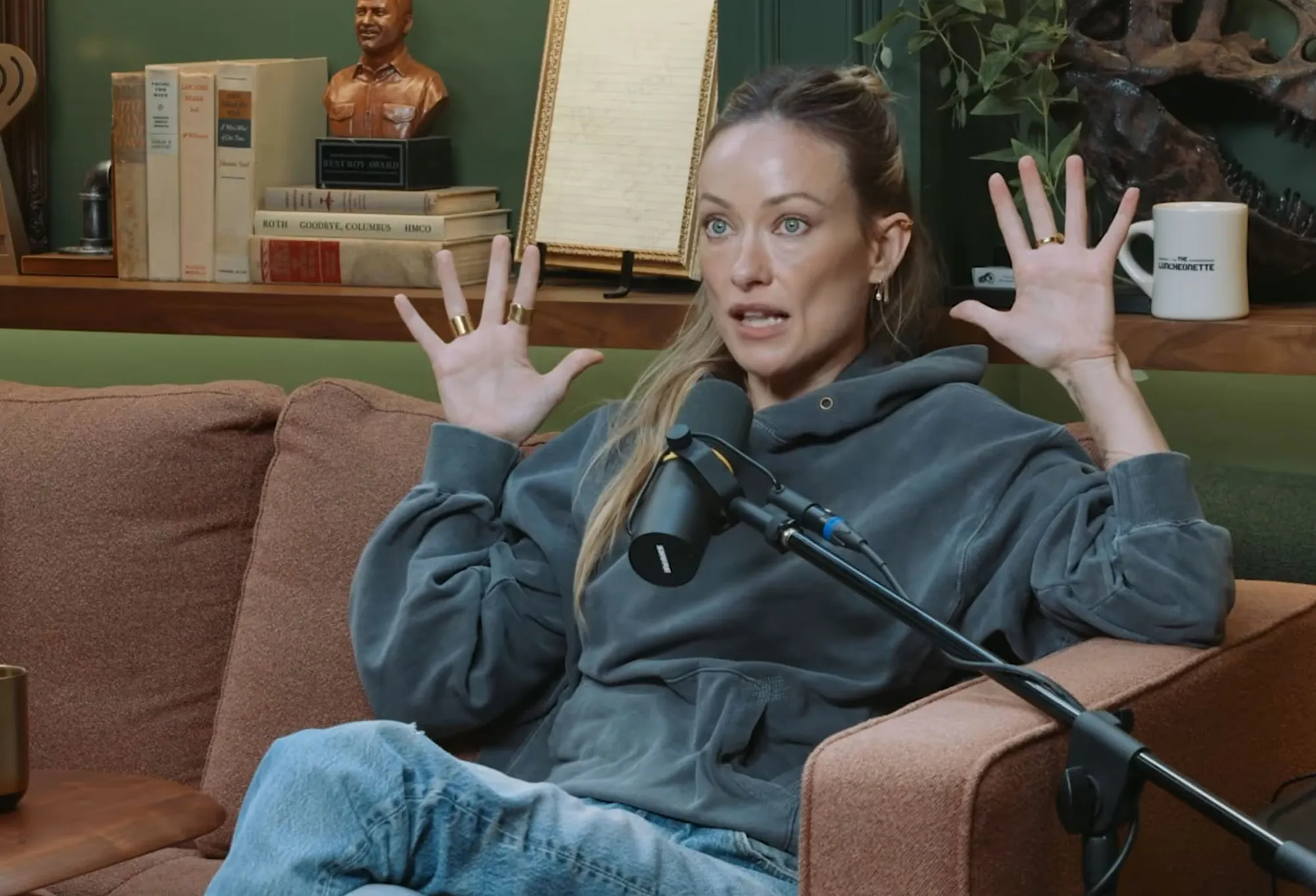 Olivia Wilde gesturing while speaking into a microphone during her 