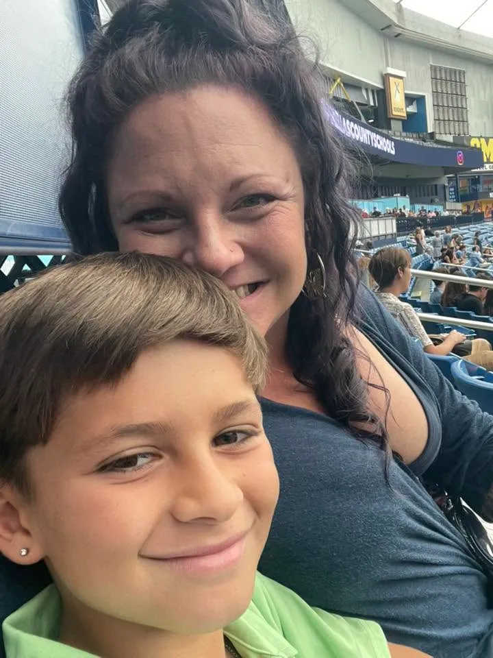 A mother and her 10-year-old son, Asher Thompson, sitting together at an outdoor event.