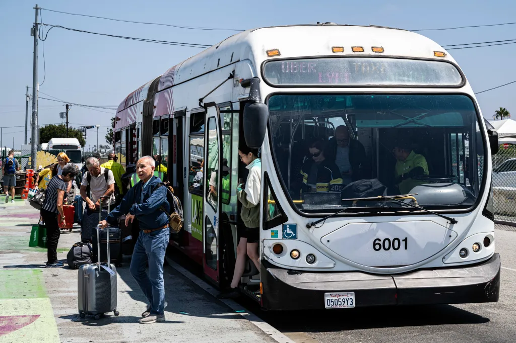Passengers departing from a rideshare bus at LAX Airport.