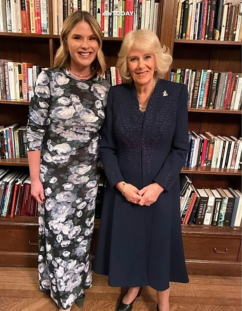 Jenna Bush Hager in a black and white patterned dress, and Queen Camilla, in a black coat, standing in front of a bookshelf.
