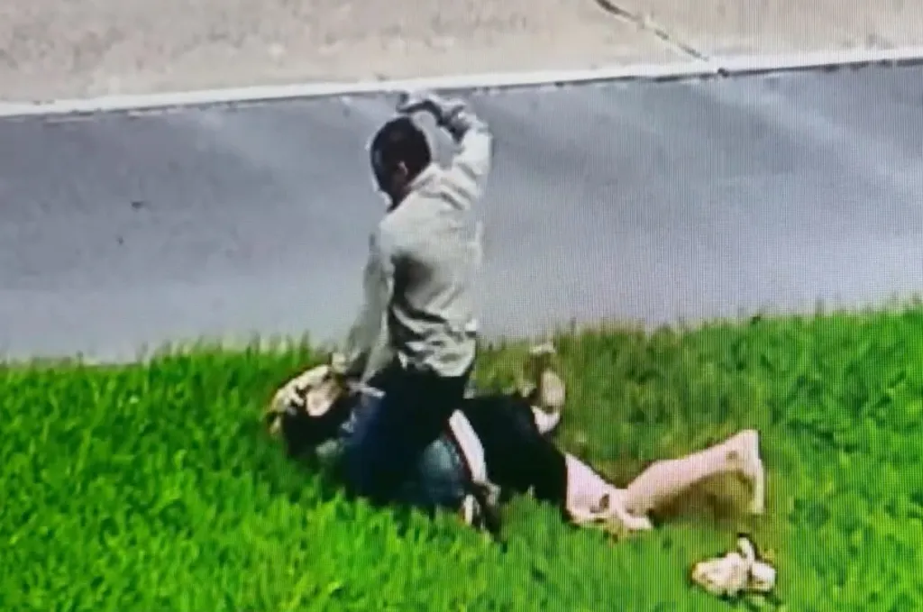 Pastor Tony Spell on top of a man on the grass.