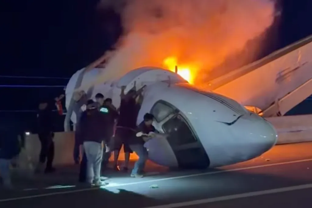 People pulling passengers from a plane on fire after crashing on a highway.