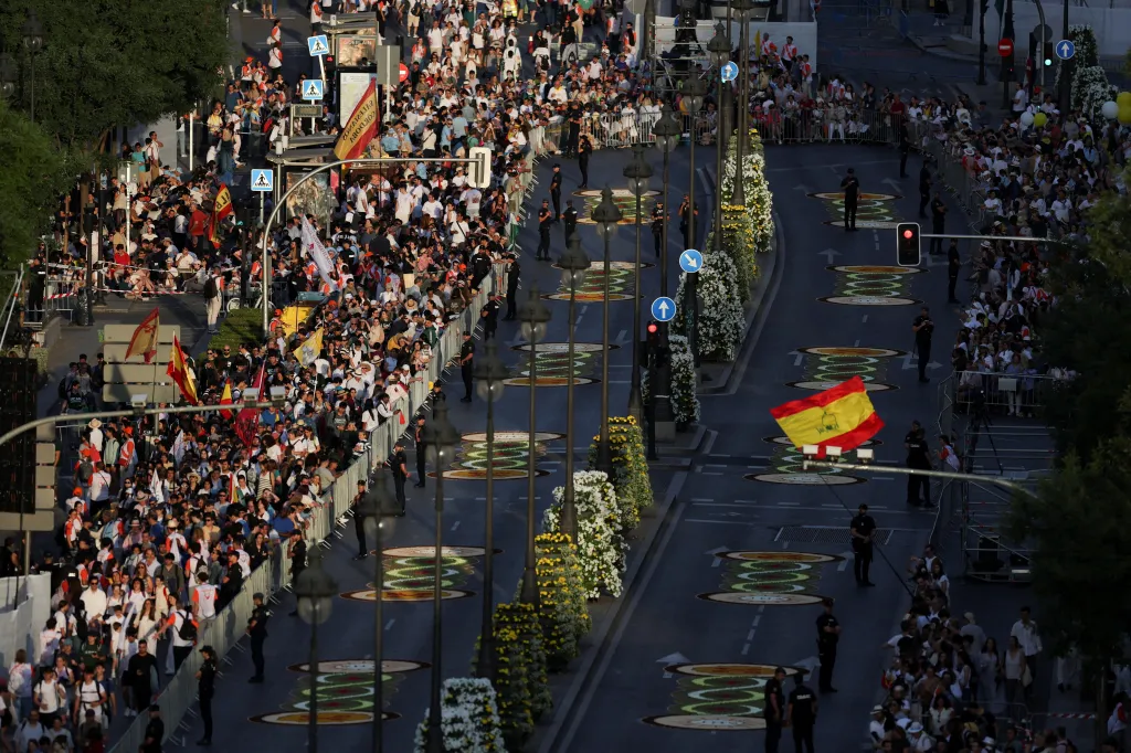 A large crowd of people gathered on a street in Madrid, Spain, awaiting the arrival of Pope Leo XIV.