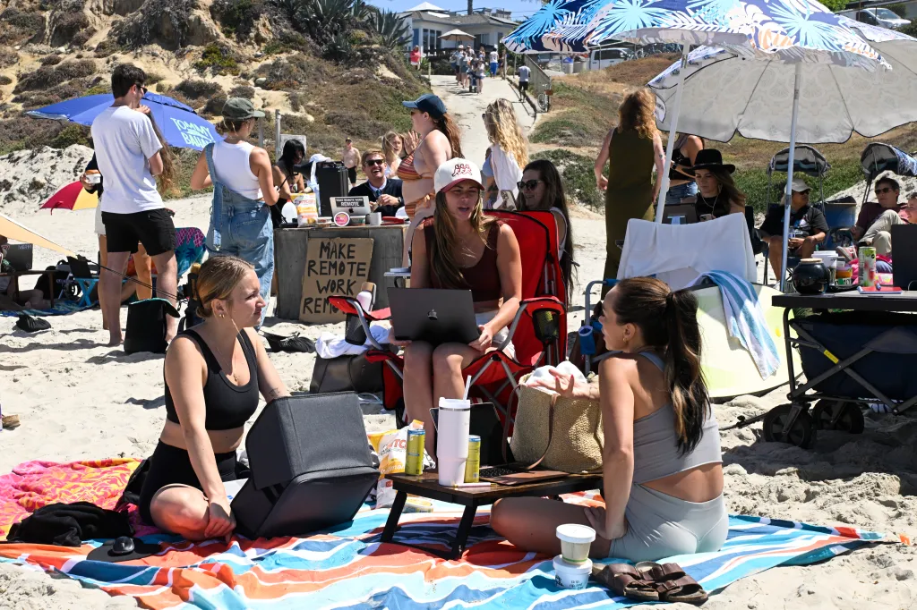 People work on the beach in Pacific Beach as they take part in a Remote Work event.